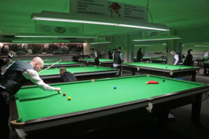 Snooker room with men playing snooker