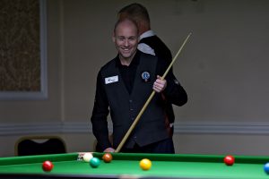 Dave Bolton smiles as he lines up a snooker shot