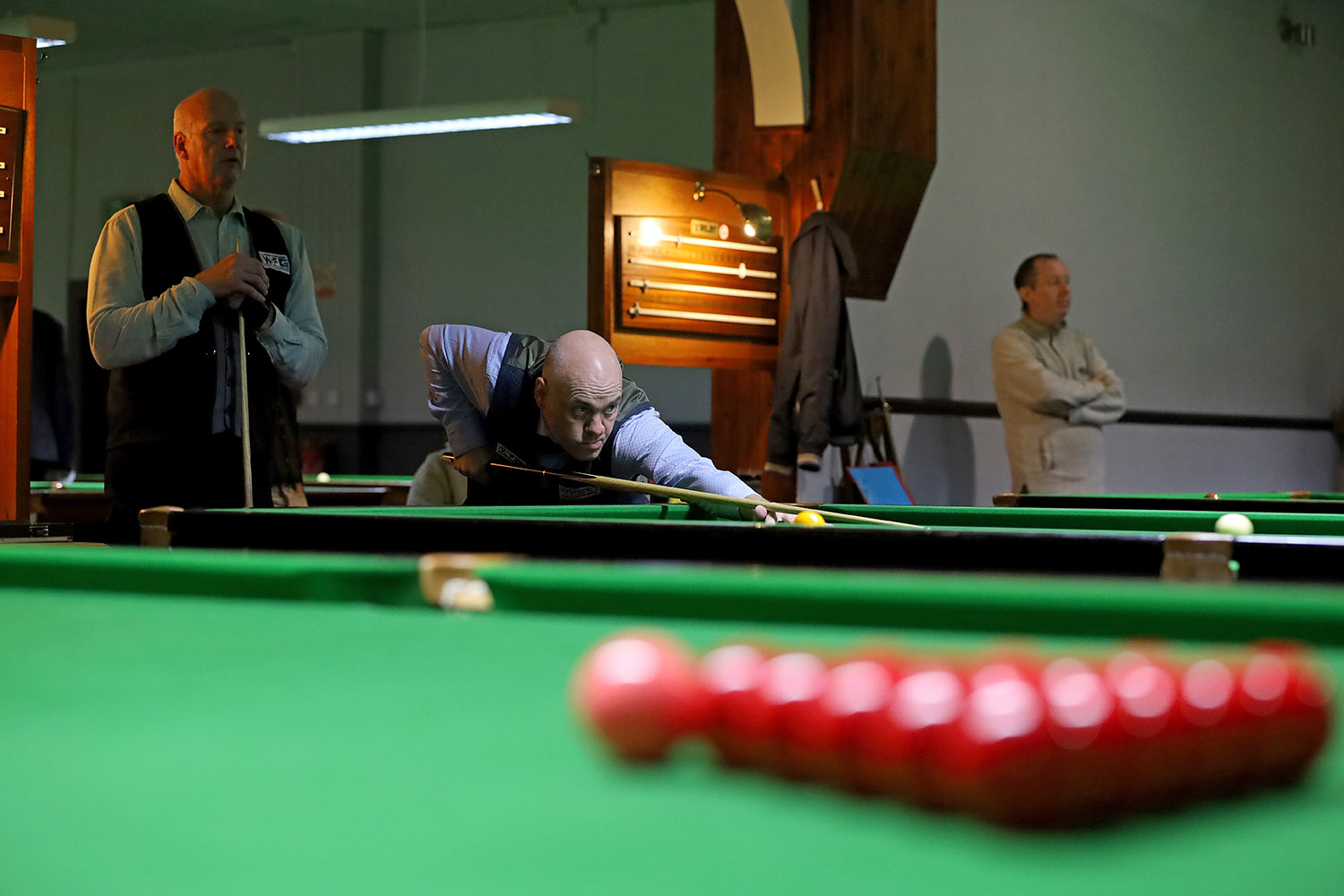 Man plays snooker while other watches