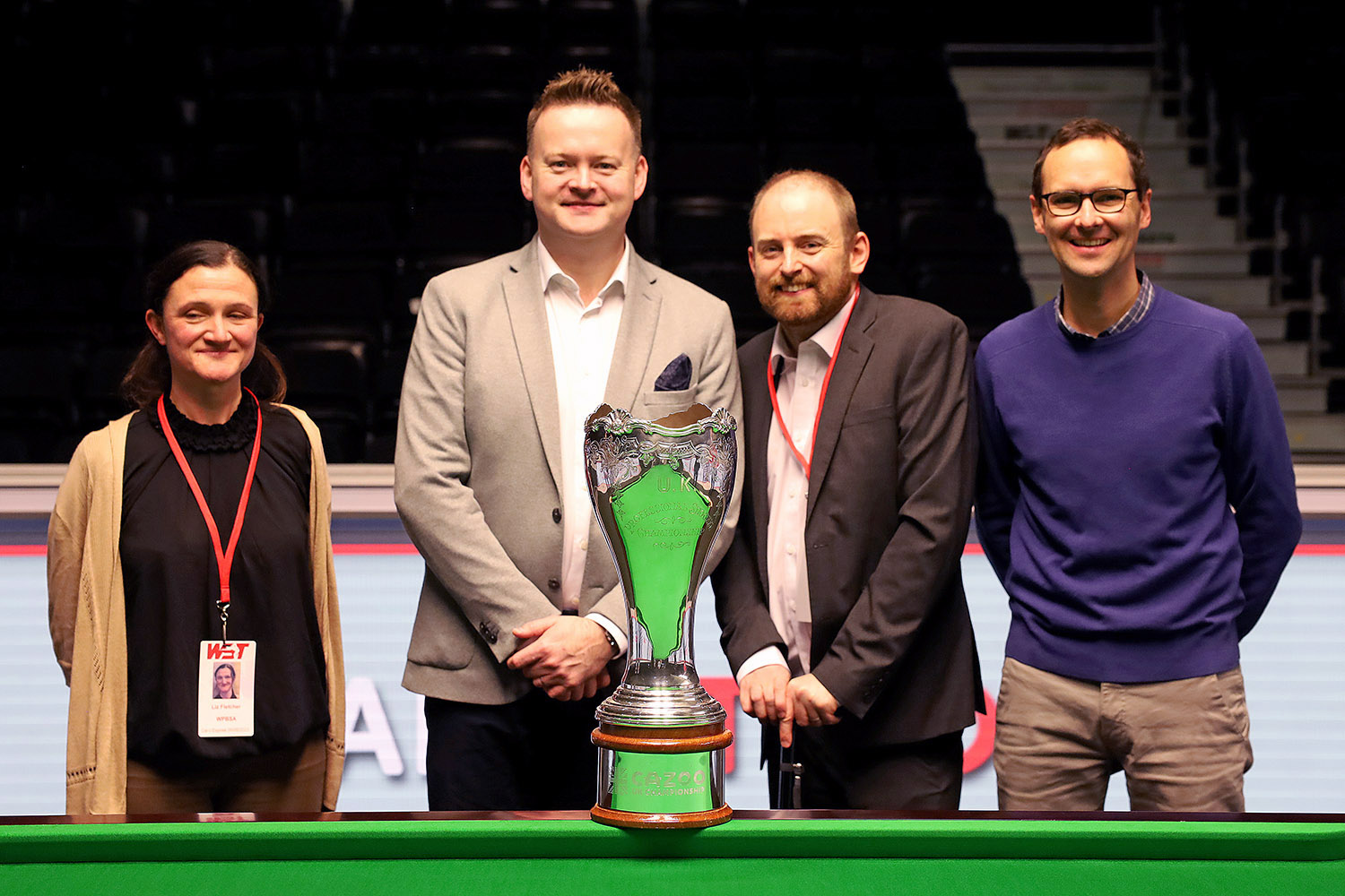 Four people stood smiling with UK Championship trophy