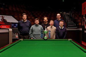 The players pose with the World Championship trophy on the arena floor of the Crucible Theatre