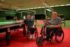 Dave Beaumont speaks with a World Abilitysport athlete by the snooker table
