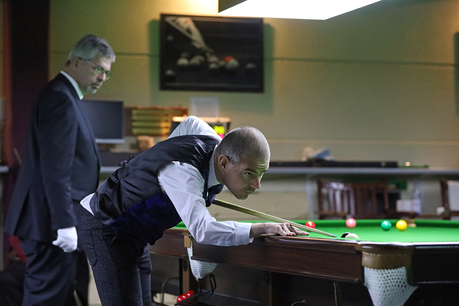 Kit Kennedy plays snooker shot with referee watching