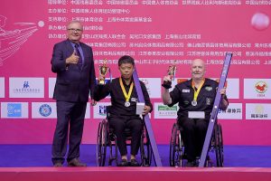 Wen Xue and Dave Beaumont hold their trophies on stage